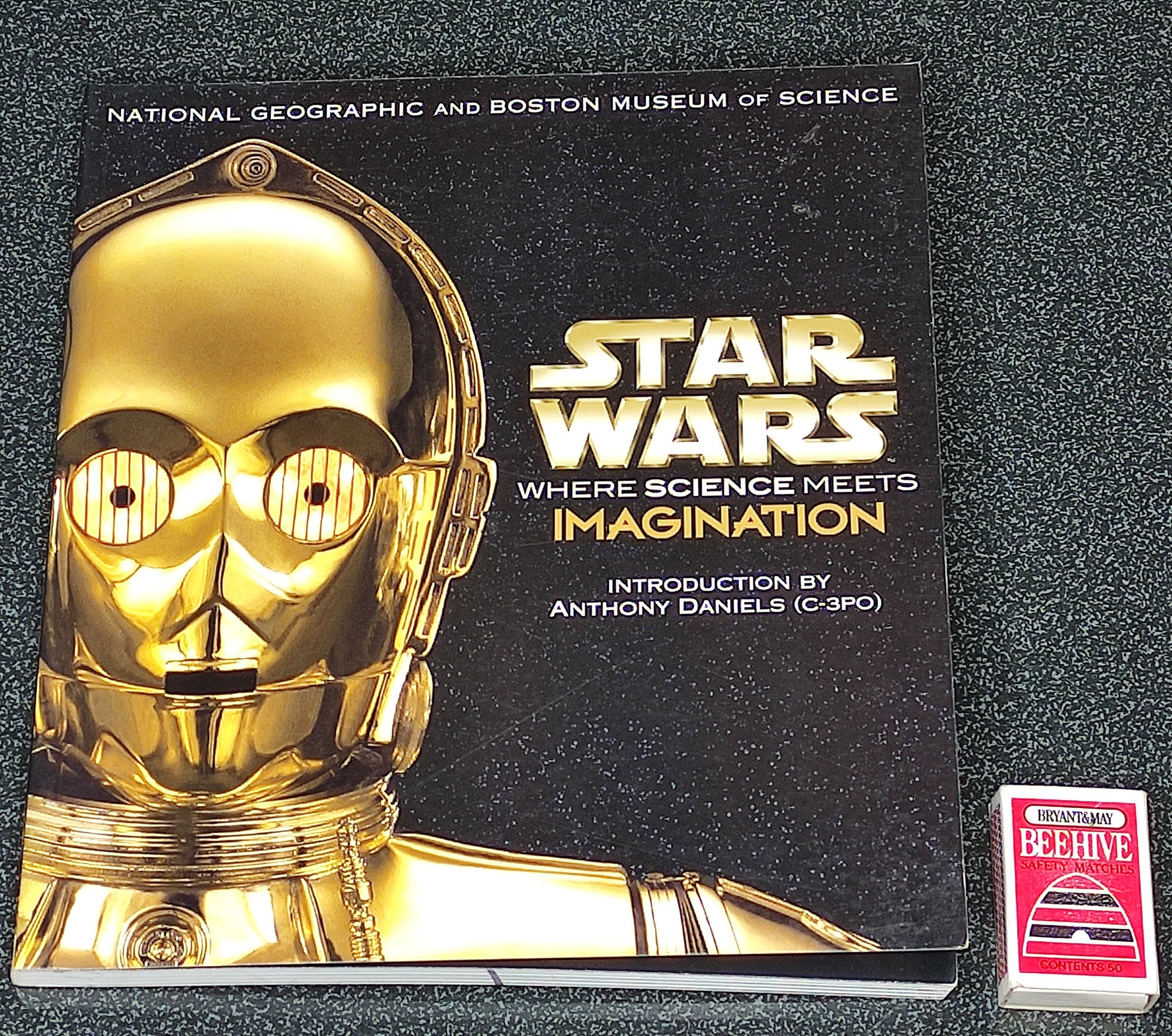 Book titled 'Star Wars: Where Science Meets Imagination' with a gold robot head on a black background.