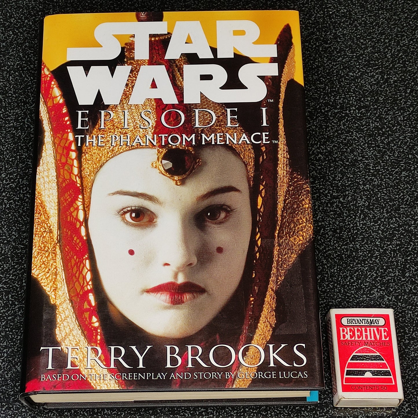 Book titled 'Star Wars Episode I: The Phantom Menace' by Terry Brooks on a textured black surface