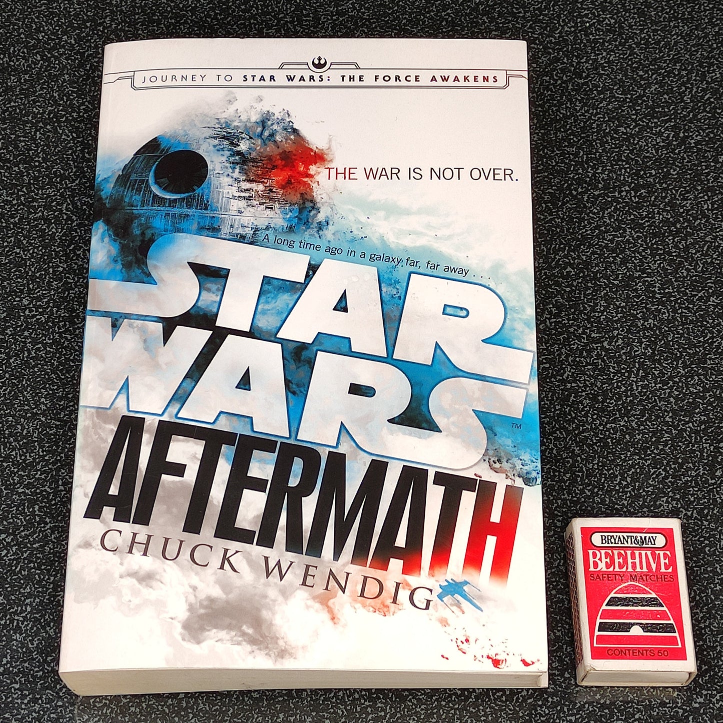 Book titled 'Star Wars: Aftermath' by Chuck Wendig on a dark textured surface