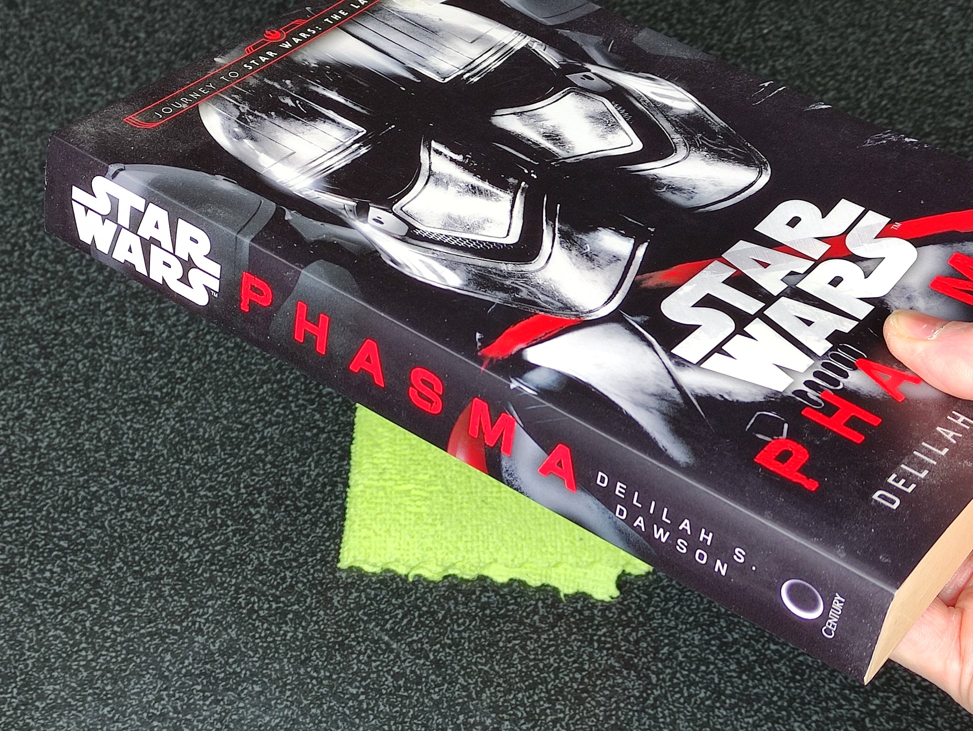 Book titled 'Star Wars: Phasma' held by a hand on a dark surface
