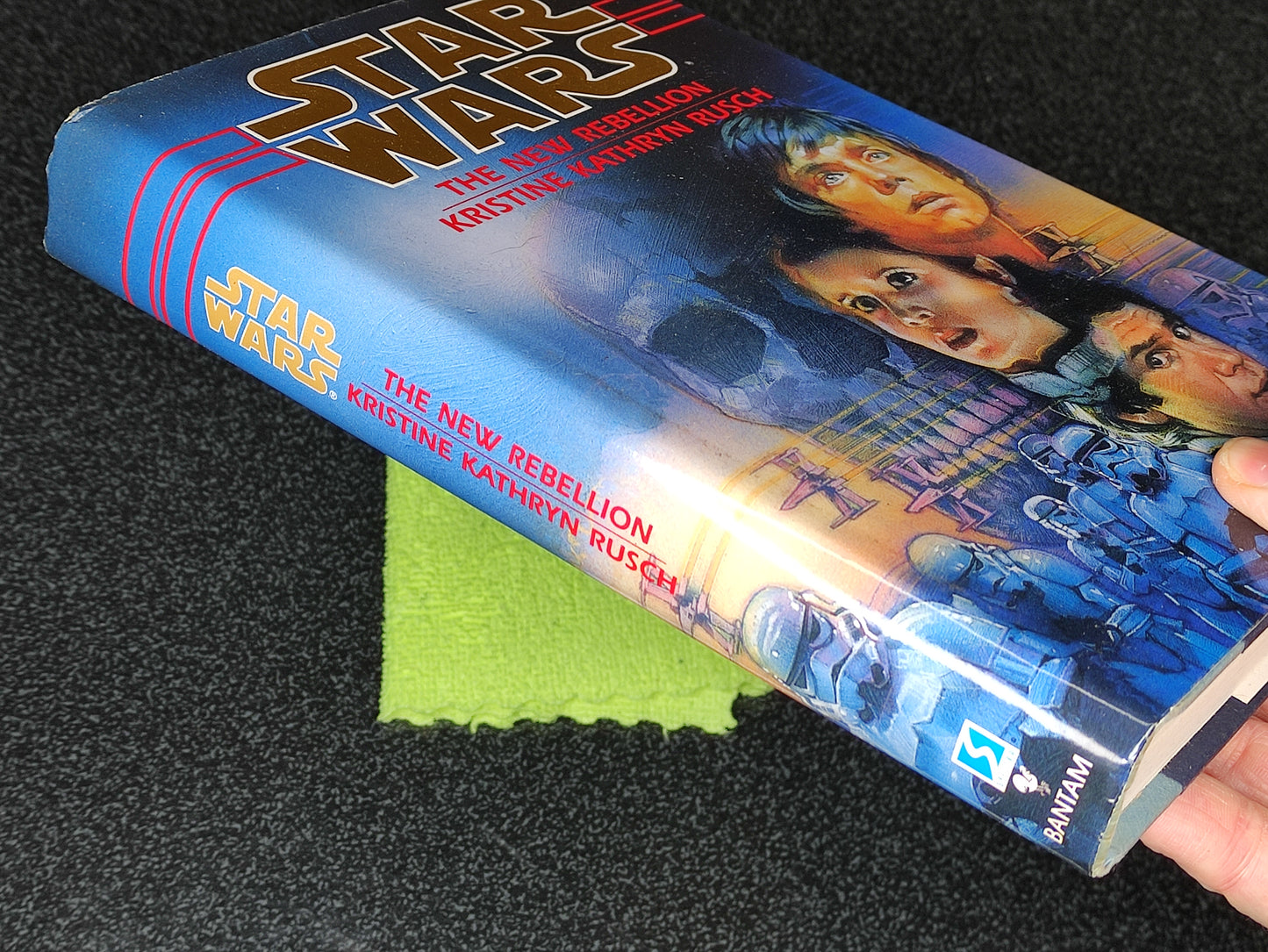 Book titled 'Star Wars: The New Rebellion' by Kristine Kathryn Rusch held against a dark background.