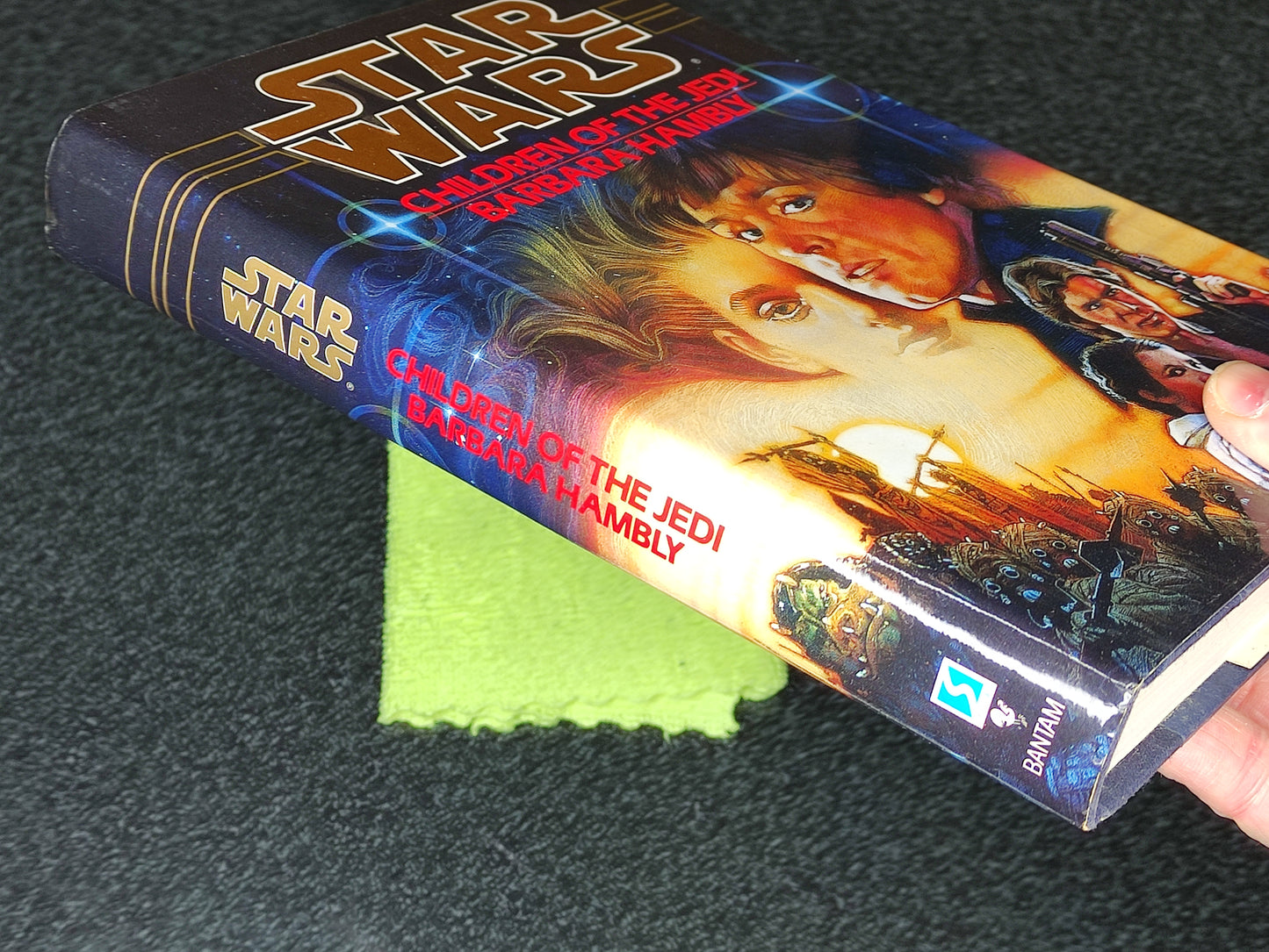 Star Wars book titled 'Children of the Jedi' held by a hand on a dark surface.