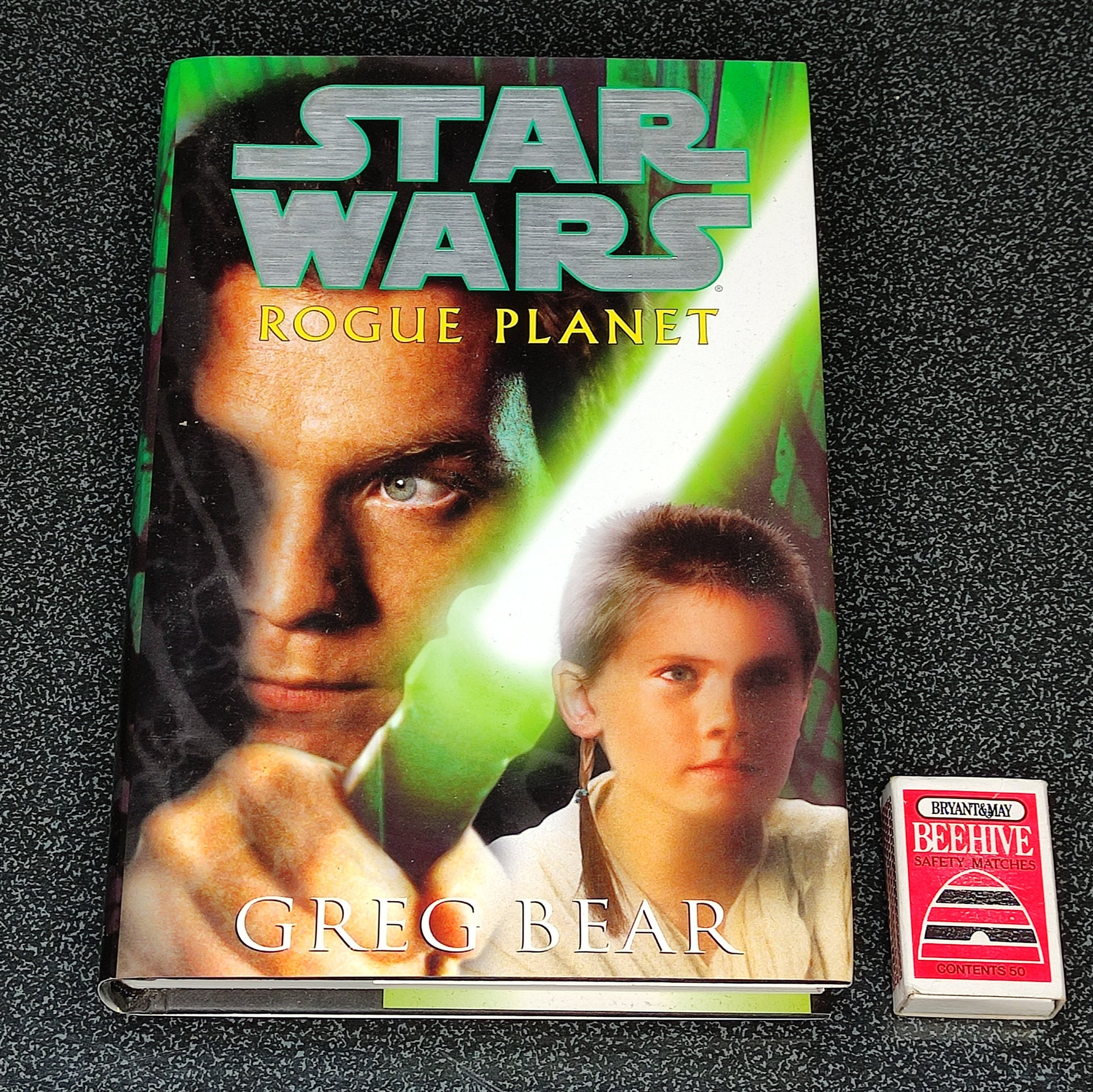Book titled 'Star Wars: Rogue Planet' by Greg Bear on a textured black surface