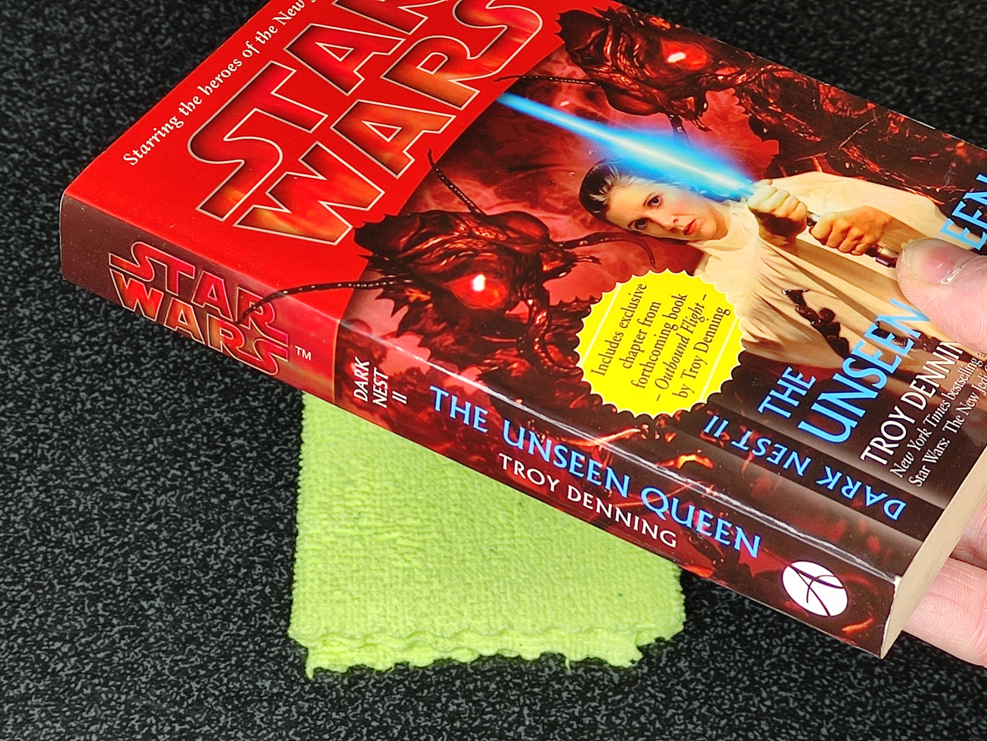 Book titled 'The Unseen Queen' by Troy Denning with a Star Wars cover on a dark surface.