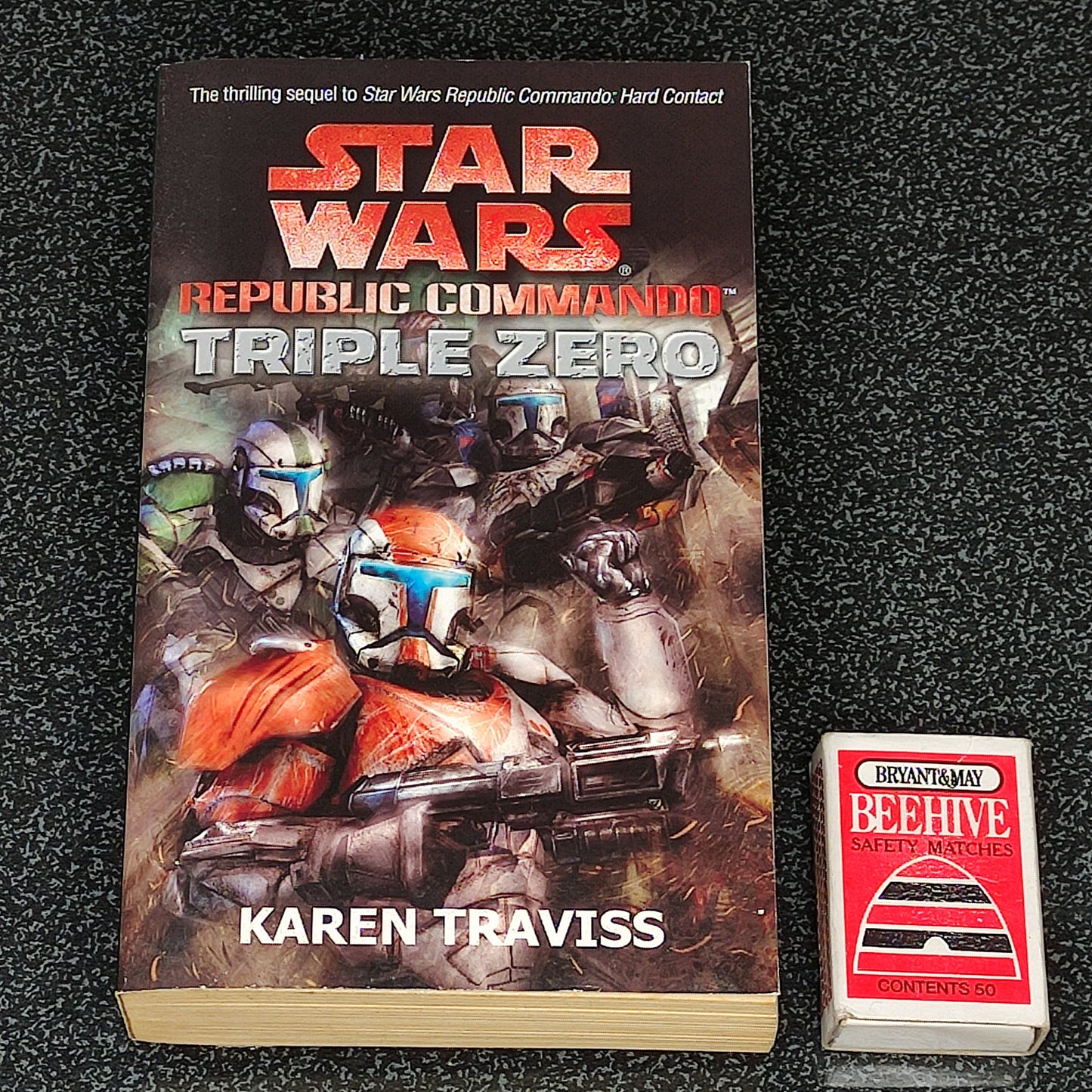 Book titled 'Star Wars: Republic Commando Triple Zero' by Karen Traviss on a textured black surface