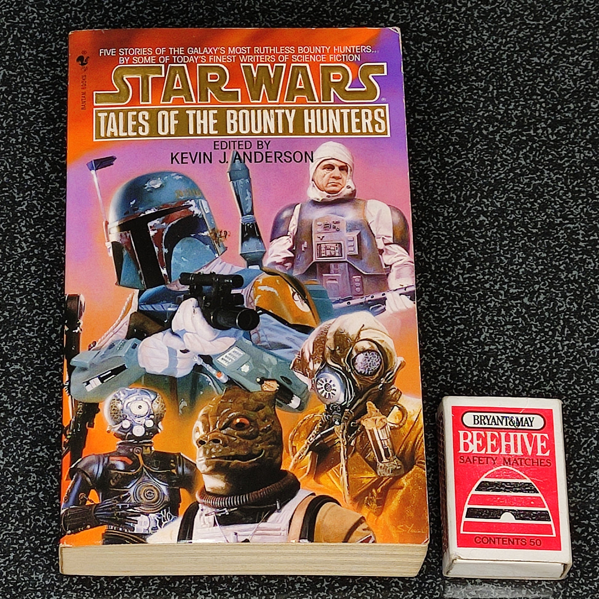 Book titled 'Star Wars: Tales of the Bounty Hunters' with action figures on a dark textured background