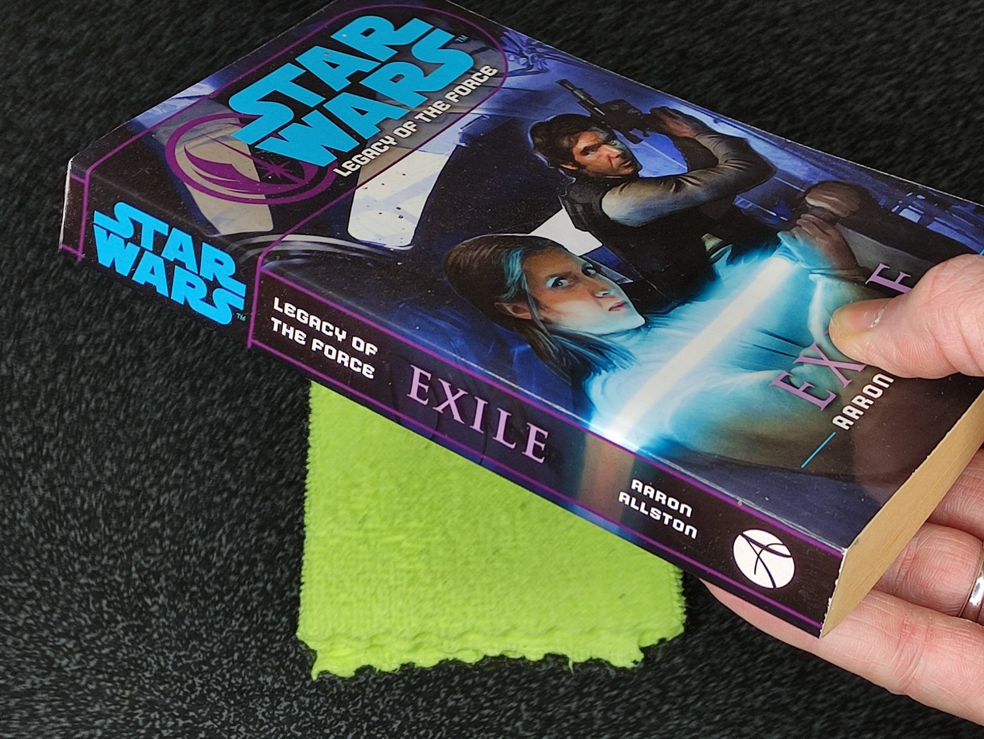 Star Wars book titled 'Exile' by Aaron Allston on a dark surface with a green cloth underneath.