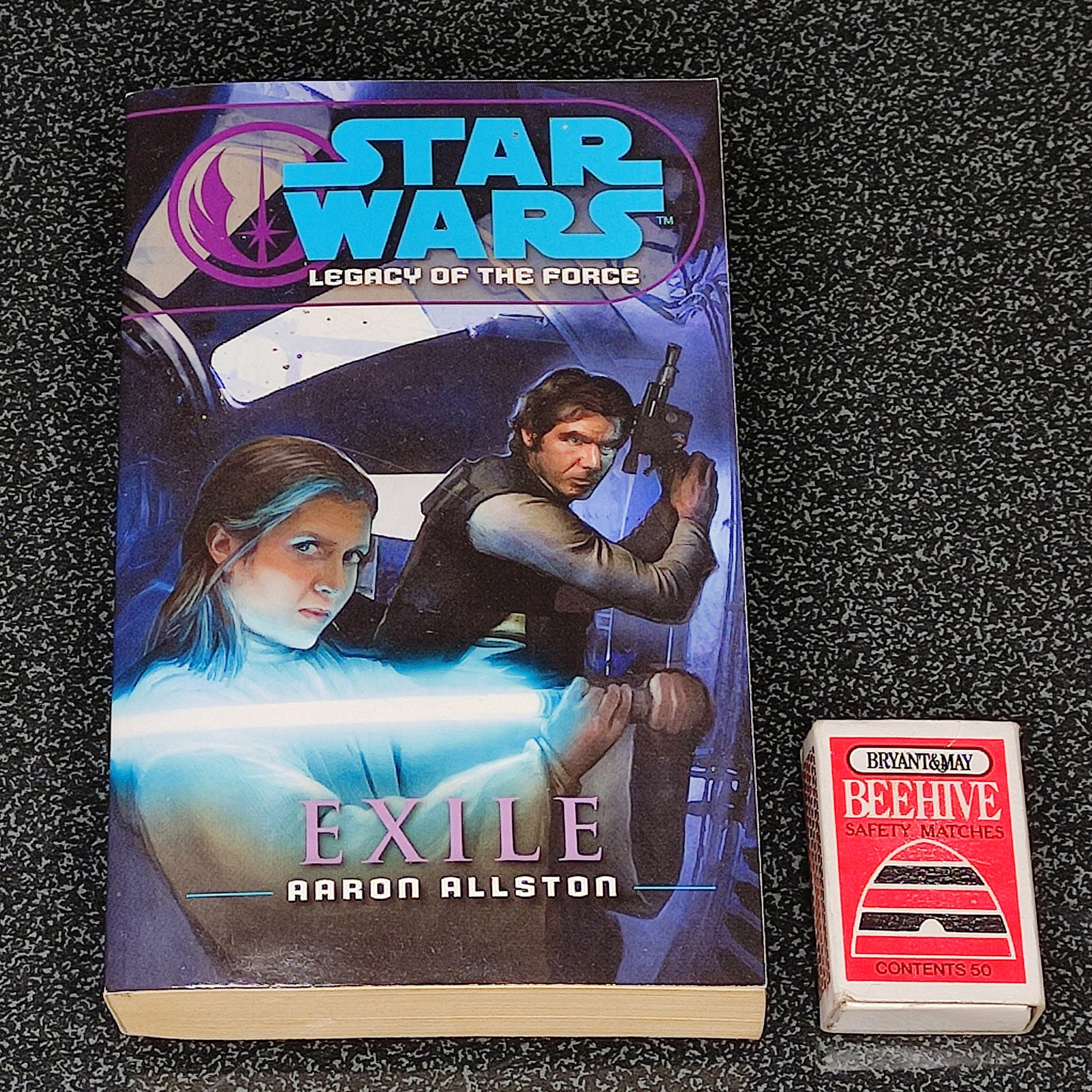 Book titled 'Exile' by Aaron Allston from the Star Wars Legacy of the Force series on a dark textured surface.