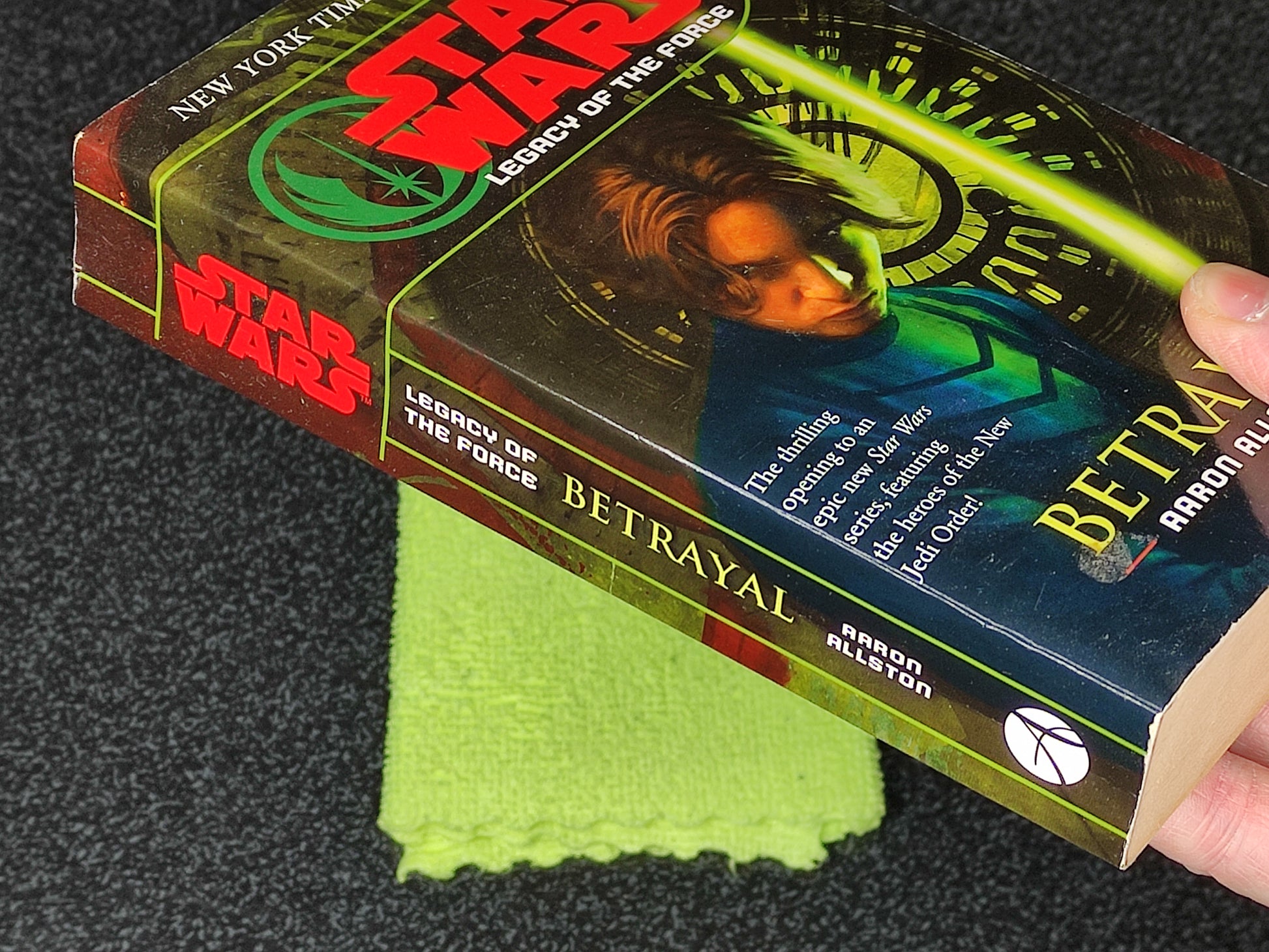 Book titled 'Betrayal' from the 'Star Wars' series held by a hand with a green cloth underneath.
