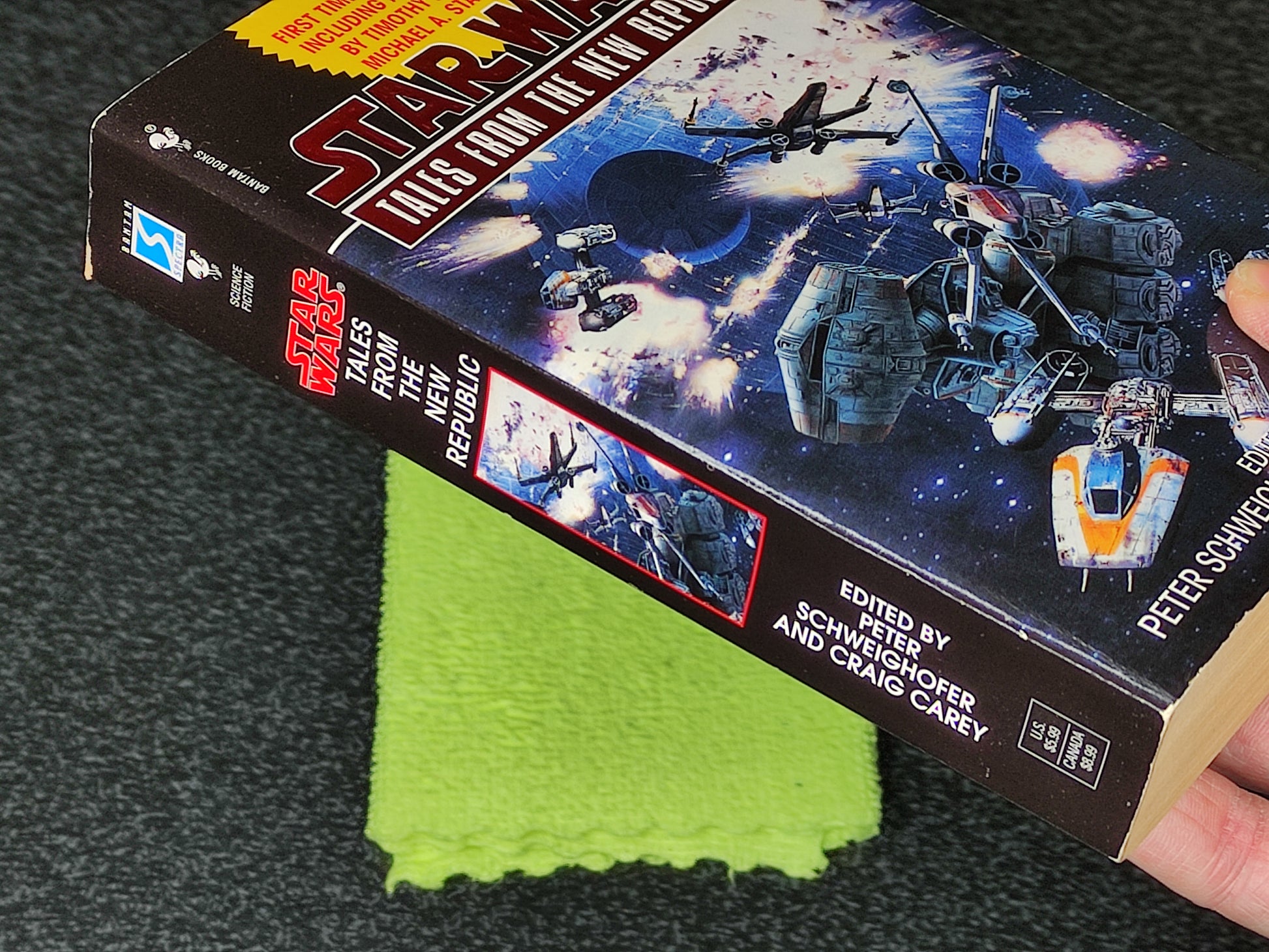 Book titled 'Star Wars: Tales from the New Republic' on a dark surface with a green cloth underneath.