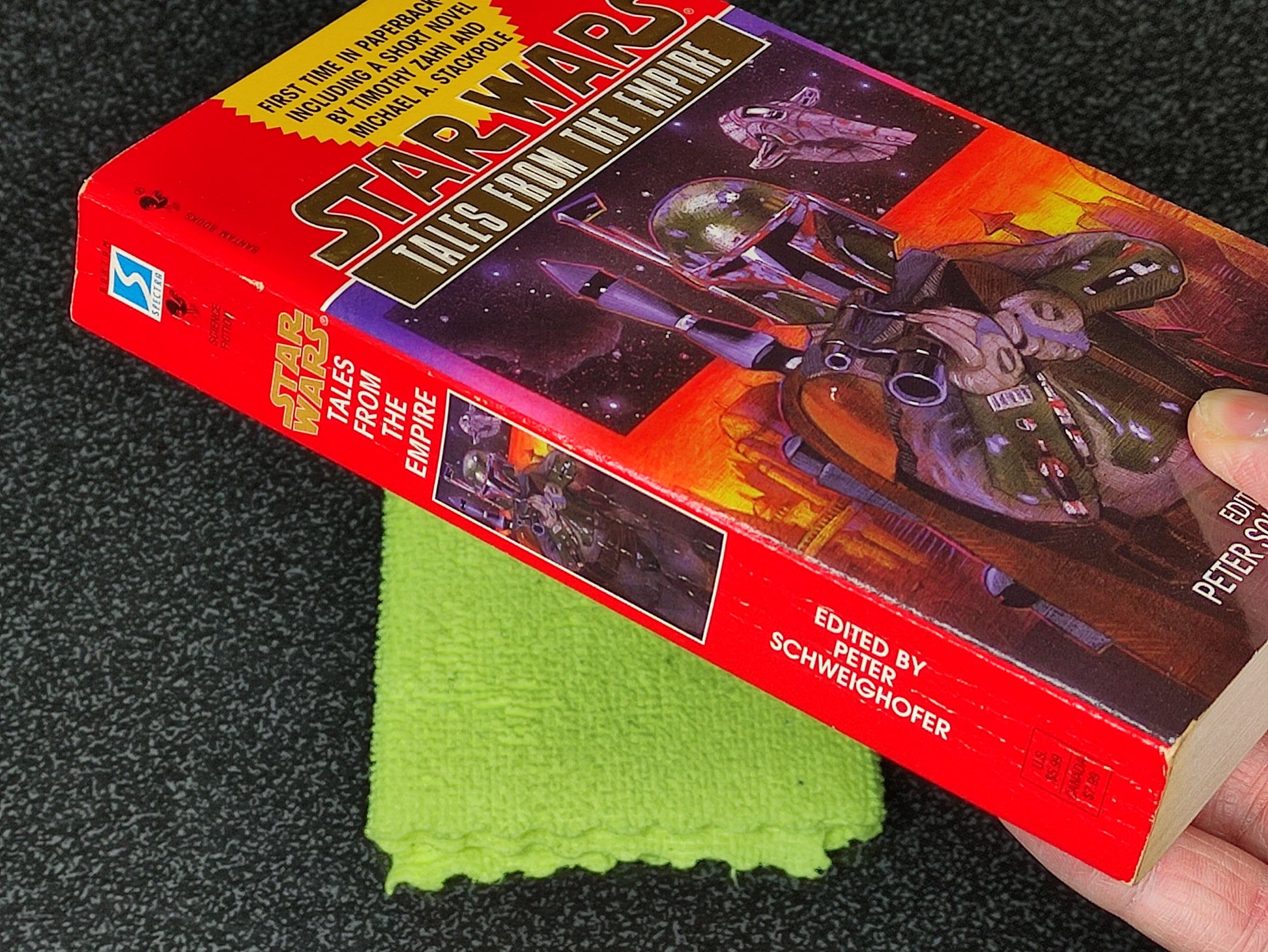 Star Wars book titled 'Tales from the Empire' held by a hand on a dark surface with a green cloth underneath.