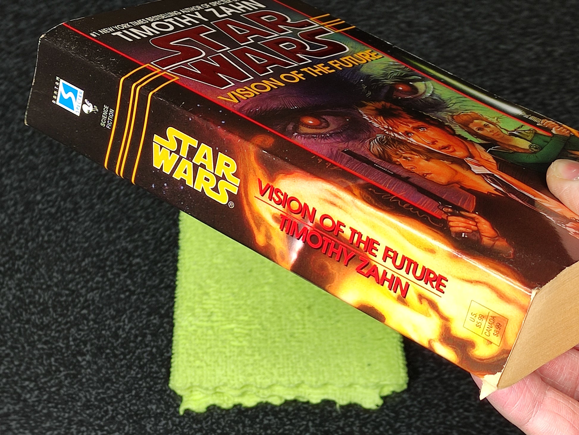 Book titled 'Star Wars: Vision of the Future' by Timothy Zahn held by a person on a dark background.