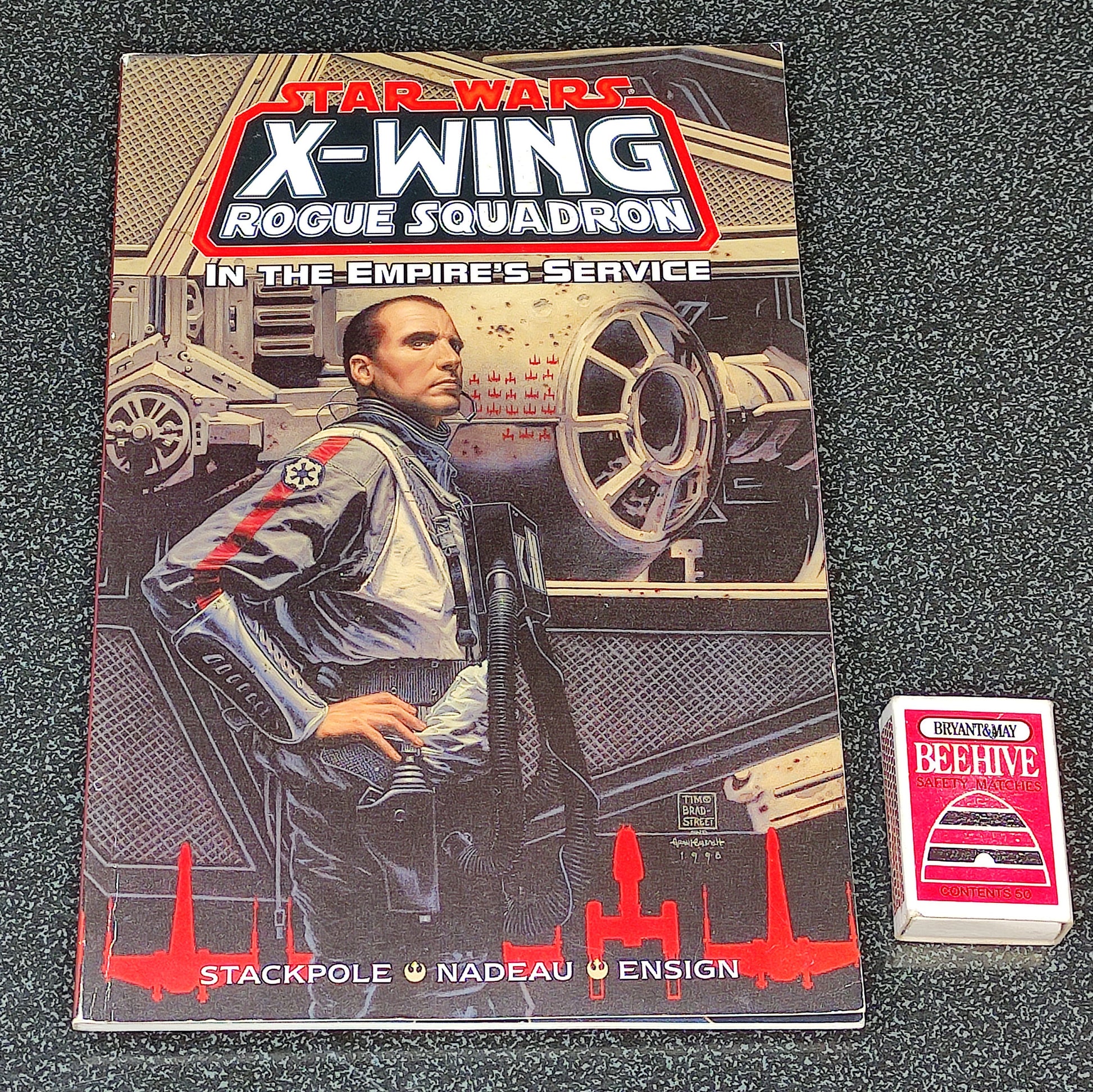 Star Wars X-Wing Rogue Squadron book with a small card on a textured surface