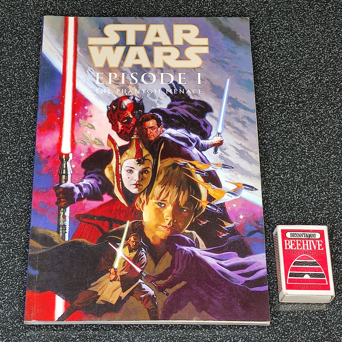 Star Wars Episode I book cover with characters and lightsabers on a dark textured background
