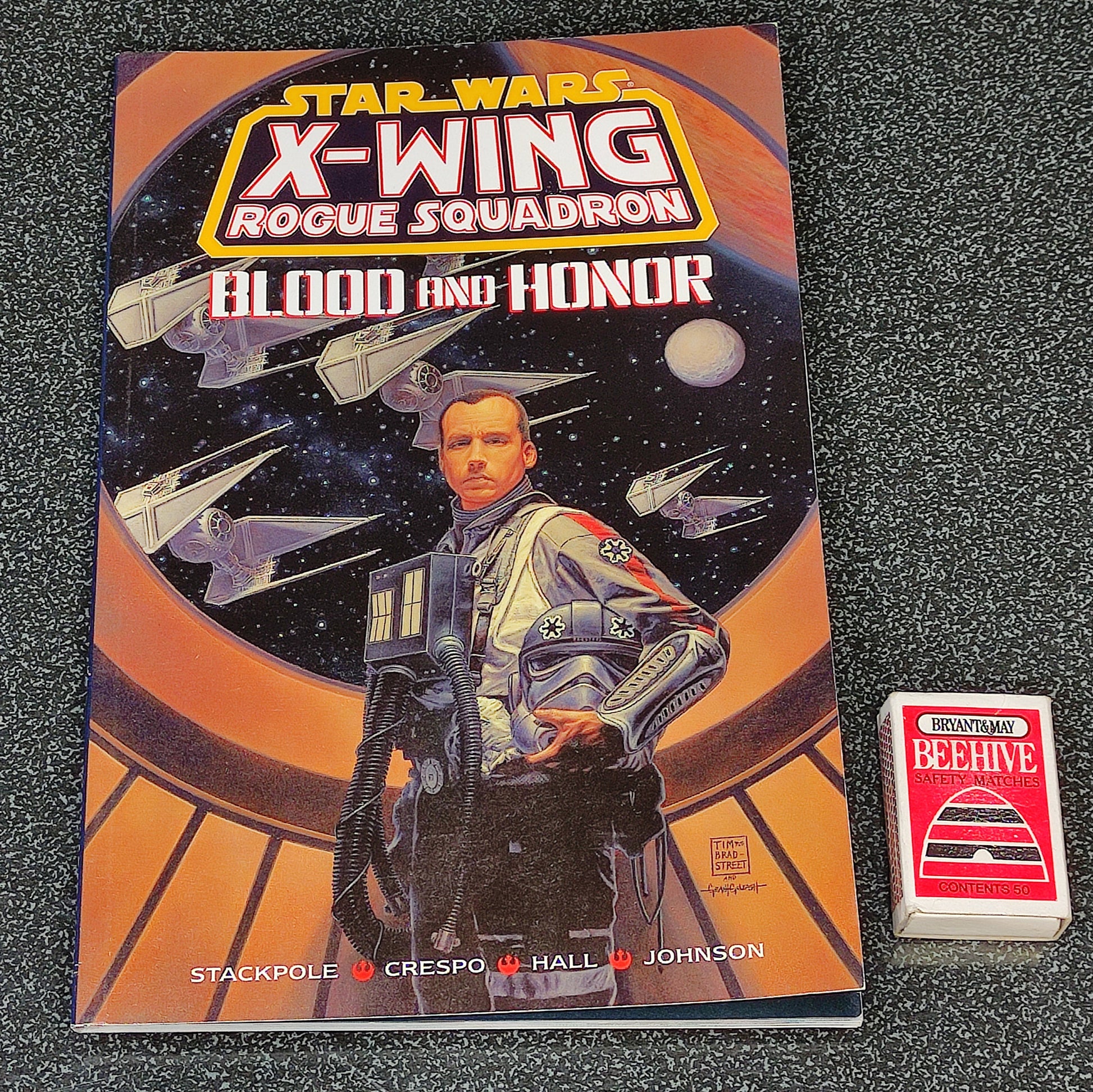 Star Wars X-Wing Rogue Squadron book with a small card on a textured surface