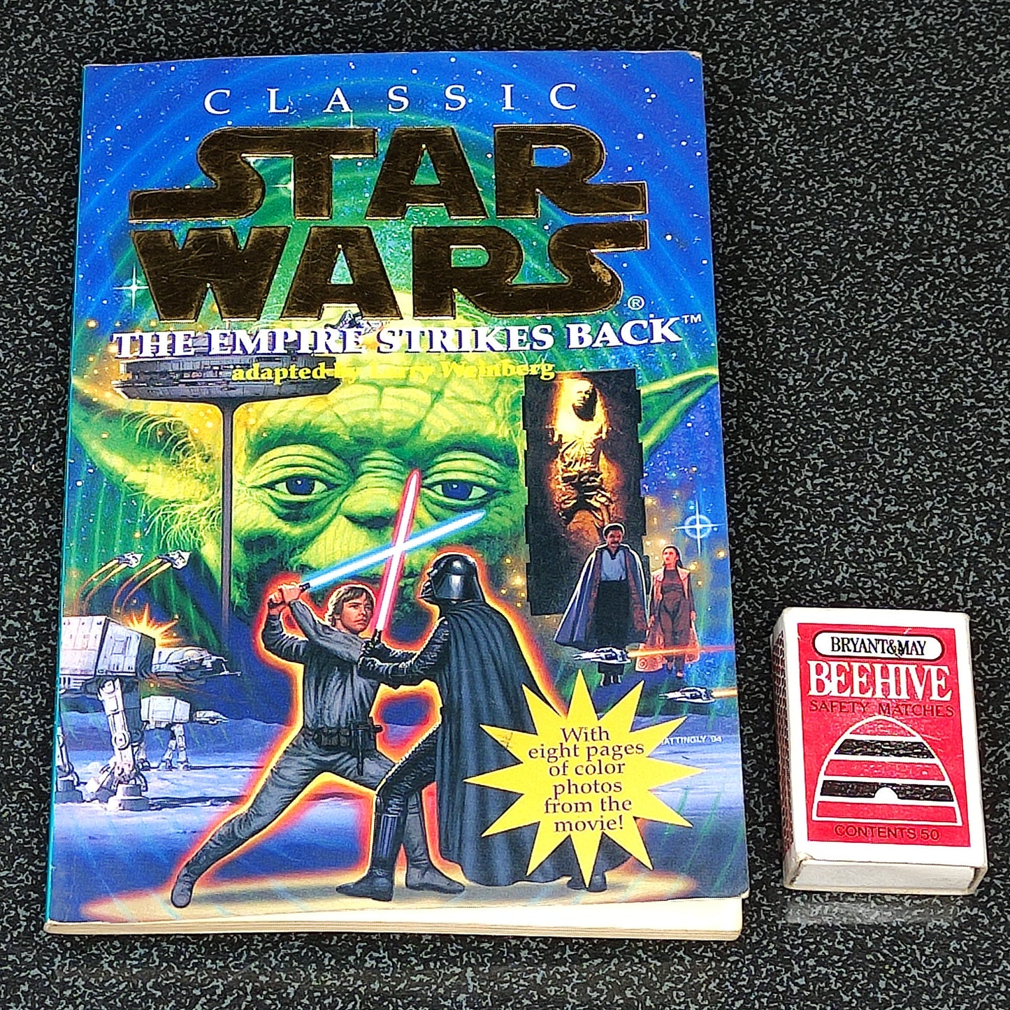 Vintage 'Star Wars' book with colorful cover featuring characters and text, placed on a textured black surface.
