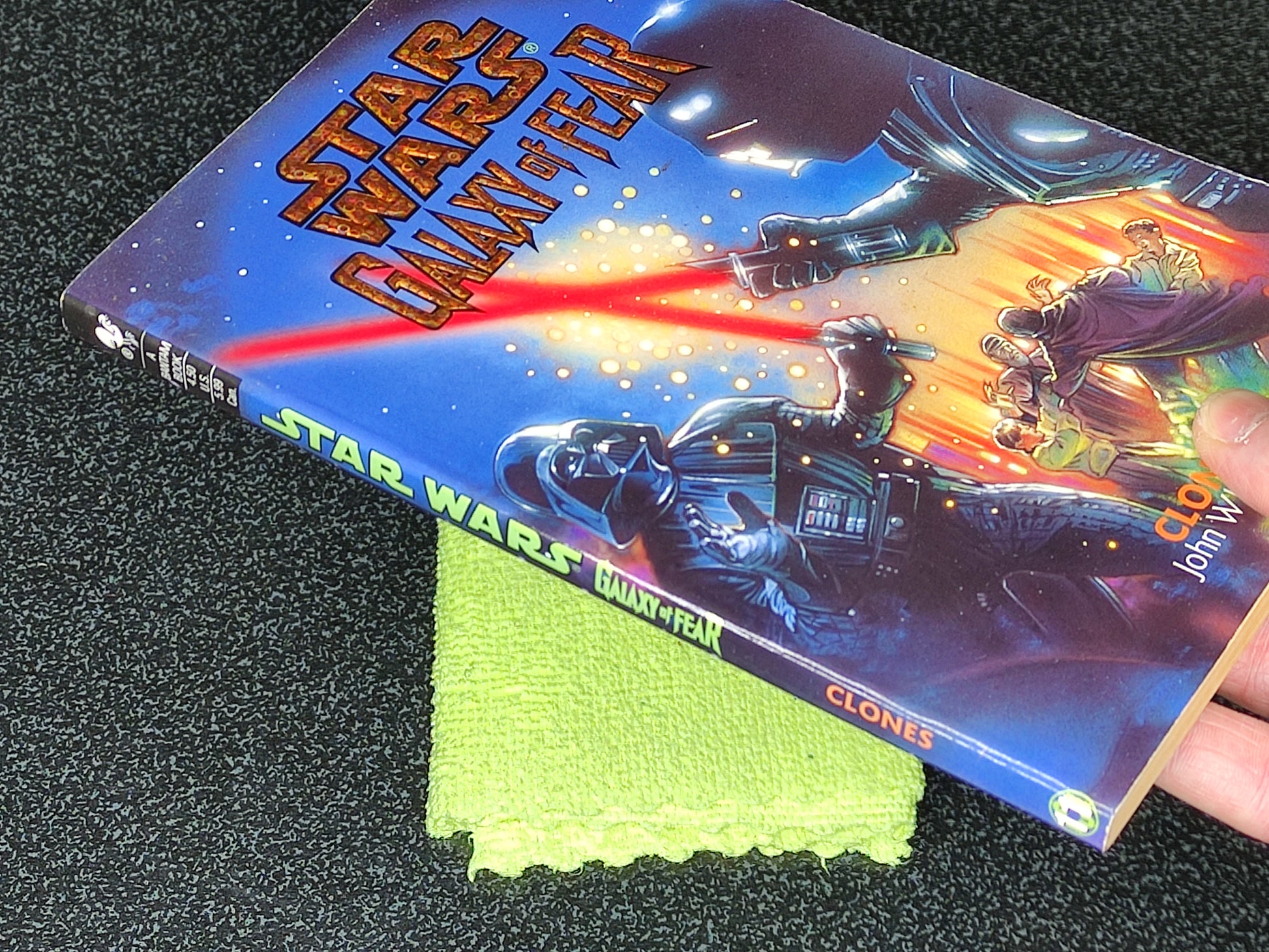 Star Wars book titled 'Clone Wars' on a dark surface with a green cloth underneath.