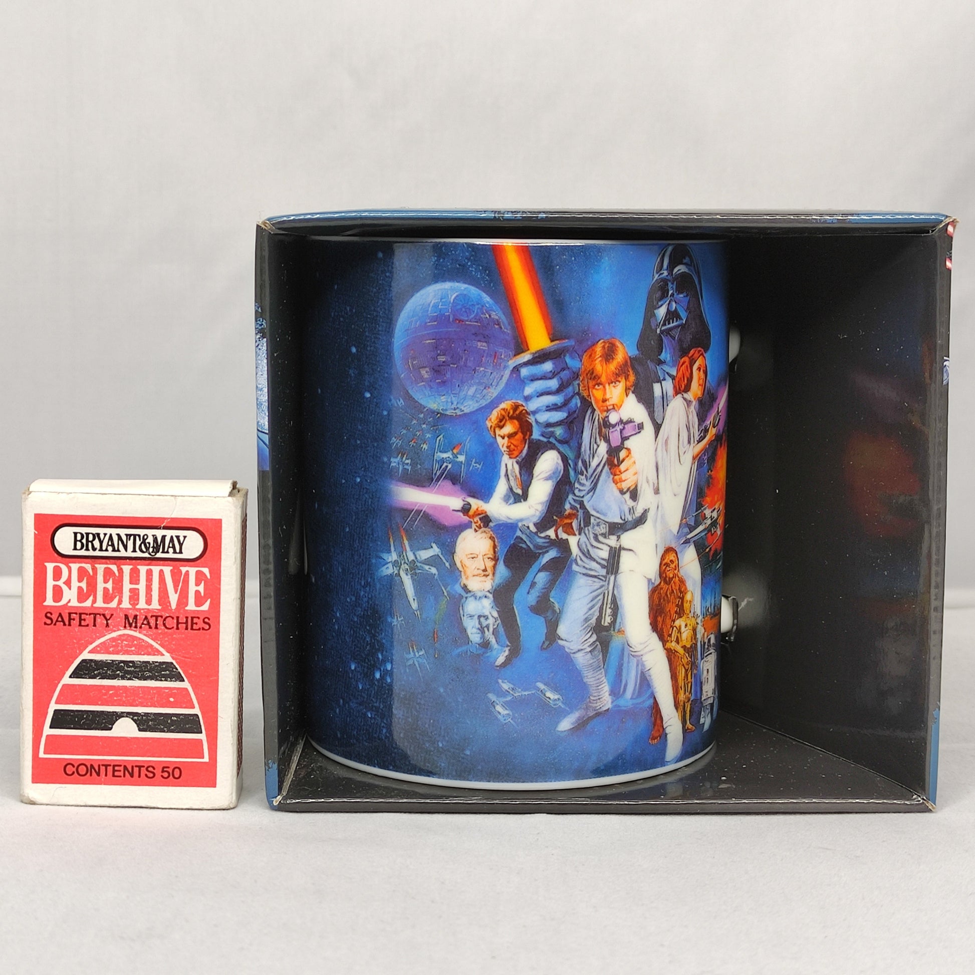 Star Wars-themed mug in packaging with a matchbox labeled 'Bryant & May Bee Hive' on a gray background.