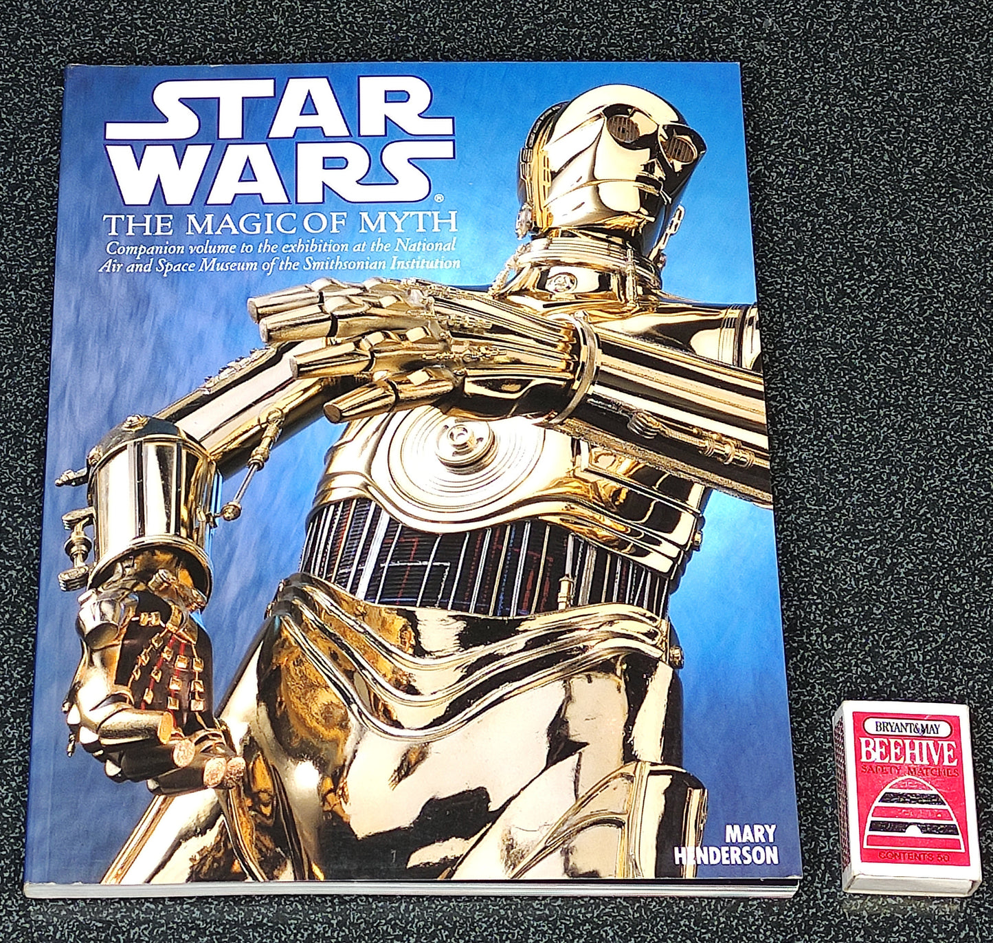 Book titled 'Star Wars: The Magic of Myth' with a gold robot on the cover, featuring a visible brand logo.