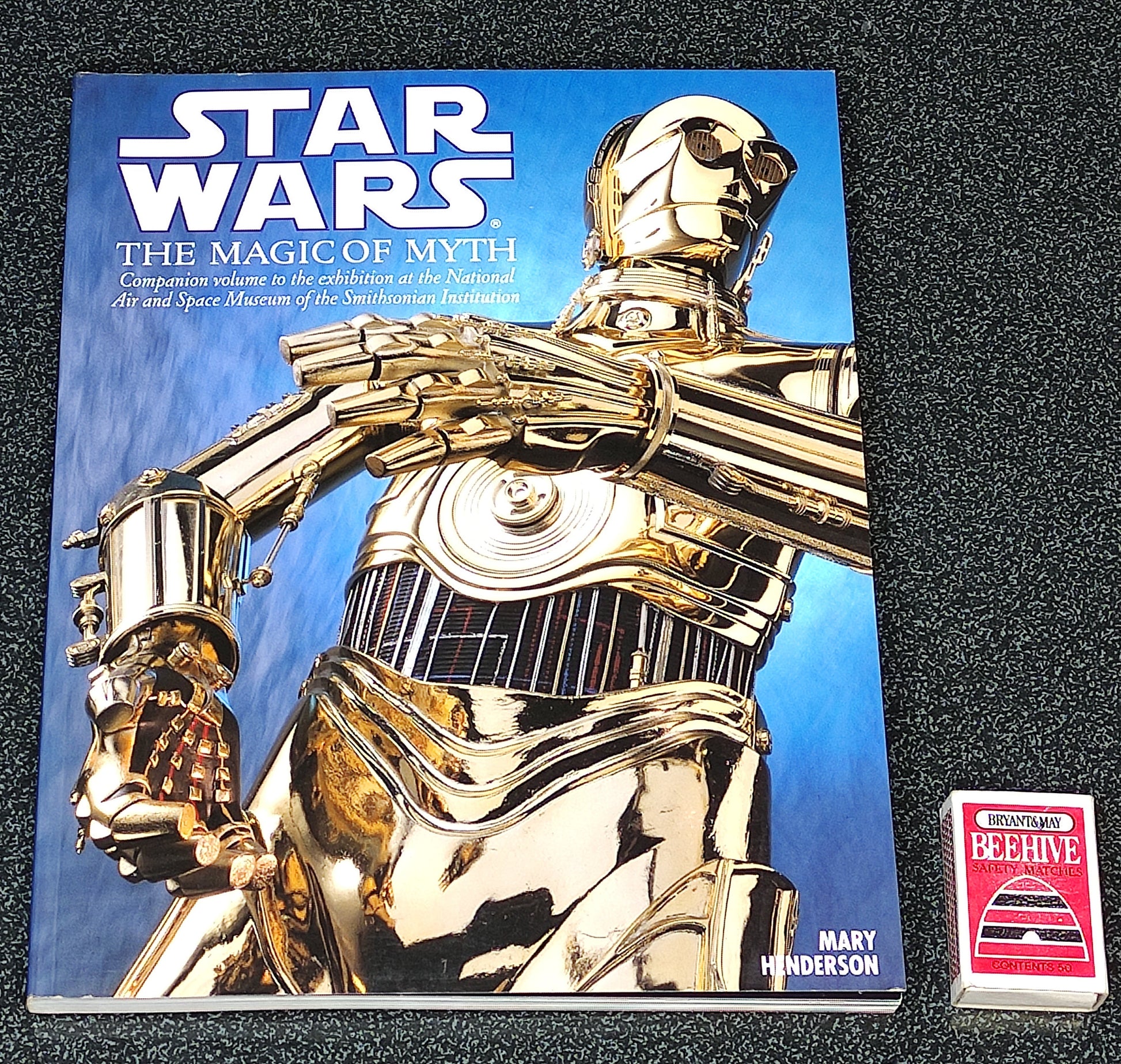 Book titled 'Star Wars: The Magic of Myth' with a gold robot on the cover, featuring a visible brand logo.