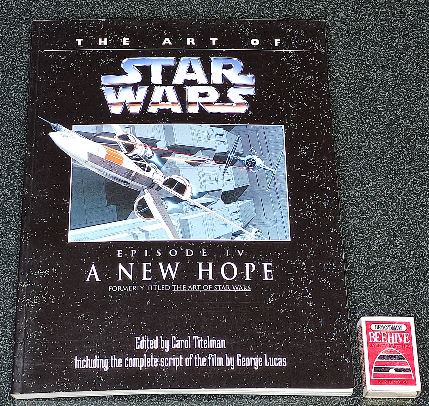 Book titled 'The Art of Star Wars Episode IV: A New Hope' on a gray background