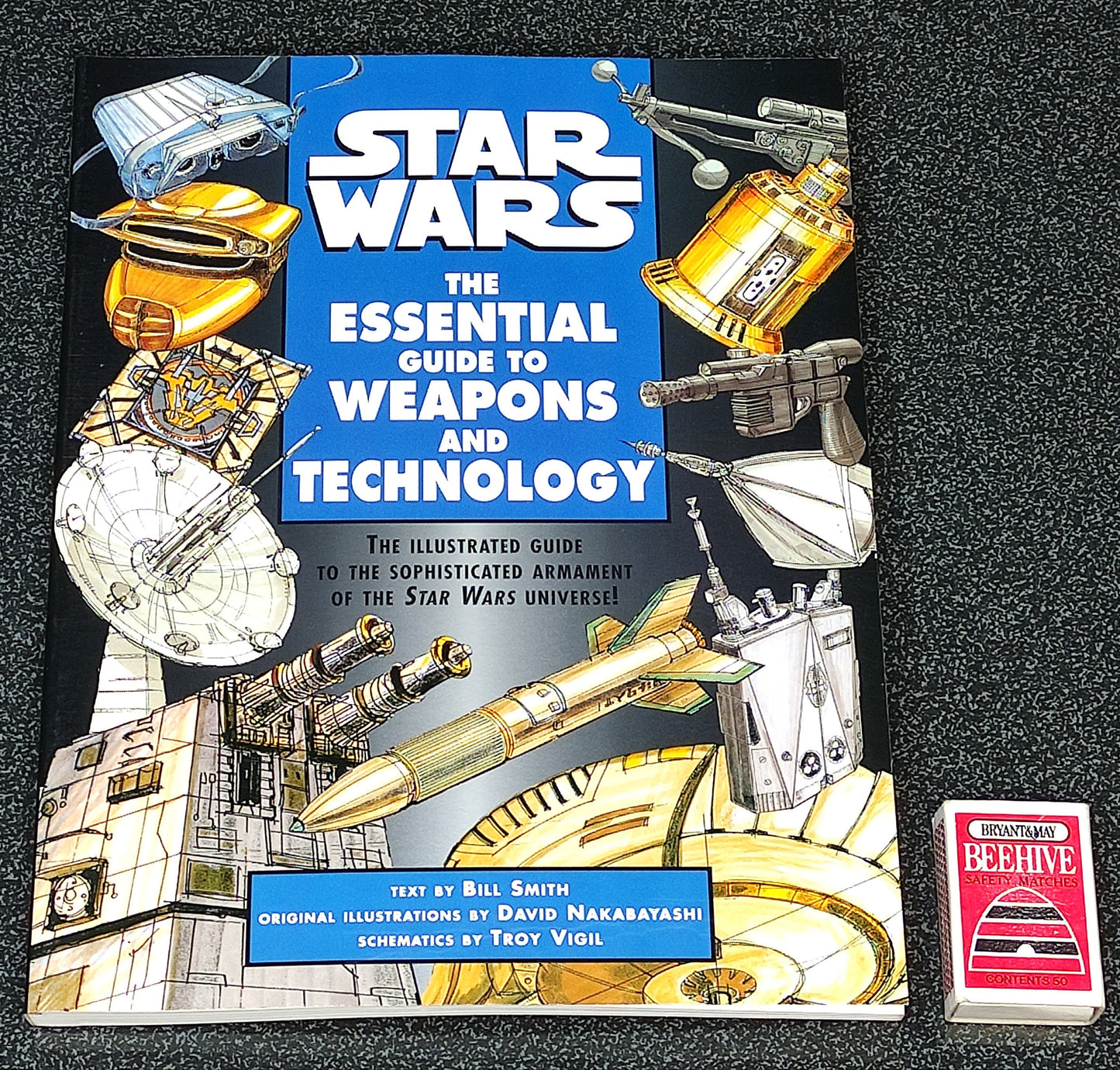 Star Wars book titled 'The Essential Guide to Weapons and Technology' on a dark surface.
