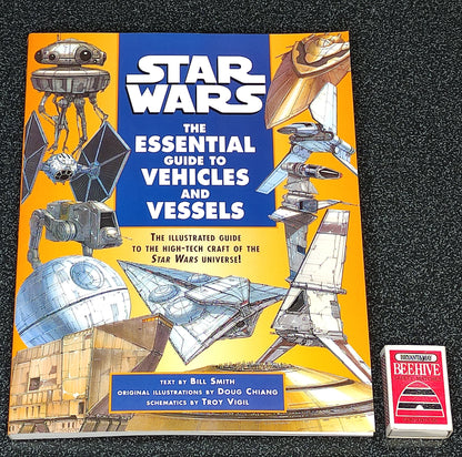 Book titled 'Star Wars: The Essential Guide to Vehicles and Vessels' on a dark textured background