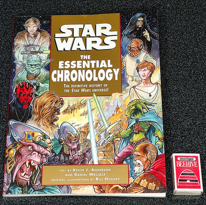Book titled 'Star Wars: The Essential Chronology' on a textured black surface with a small red and white box.