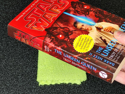 Book titled 'The Unseen Queen' by Troy Denning with a Star Wars cover on a dark surface.