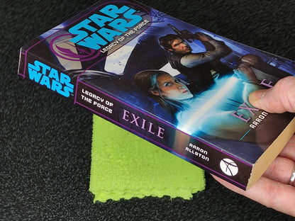 Star Wars book titled 'Exile' by Aaron Allston on a dark surface with a green cloth underneath.