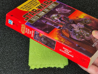Star Wars book titled 'Tales from the Empire' held by a hand on a dark surface with a green cloth underneath.