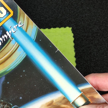 Person holding a 'Star Wars Forces of the Empire' book with a blue lightsaber