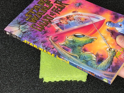 Book titled 'Star Wars: Bantam Year' with a colorful cover featuring space-themed artwork, held open by a green cloth.