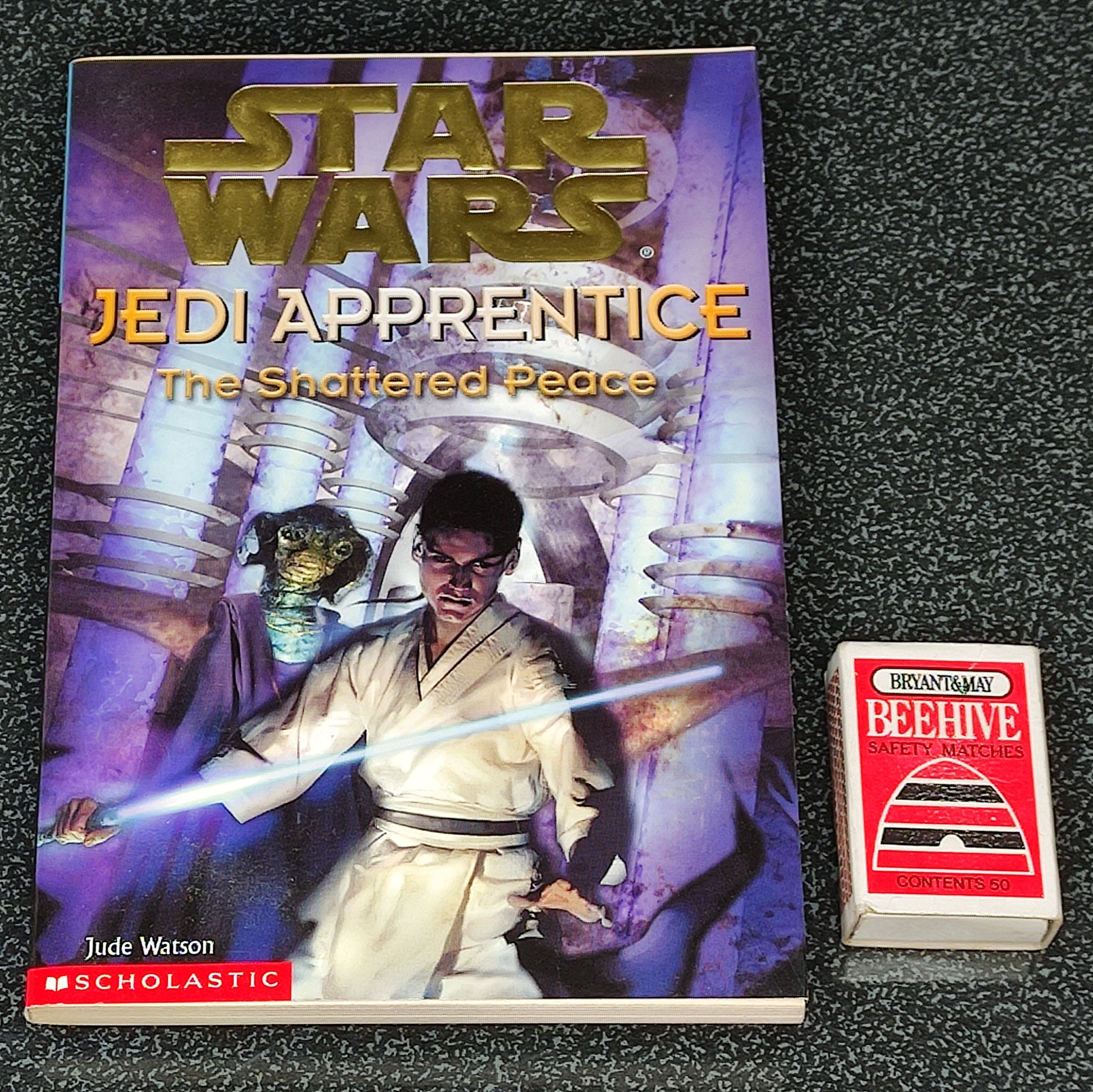 Star Wars Jedi Apprentice book with a deck of cards on a dark textured surface