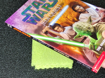 Star Wars Jedi Quest book with a green lightsaber prop on a dark surface