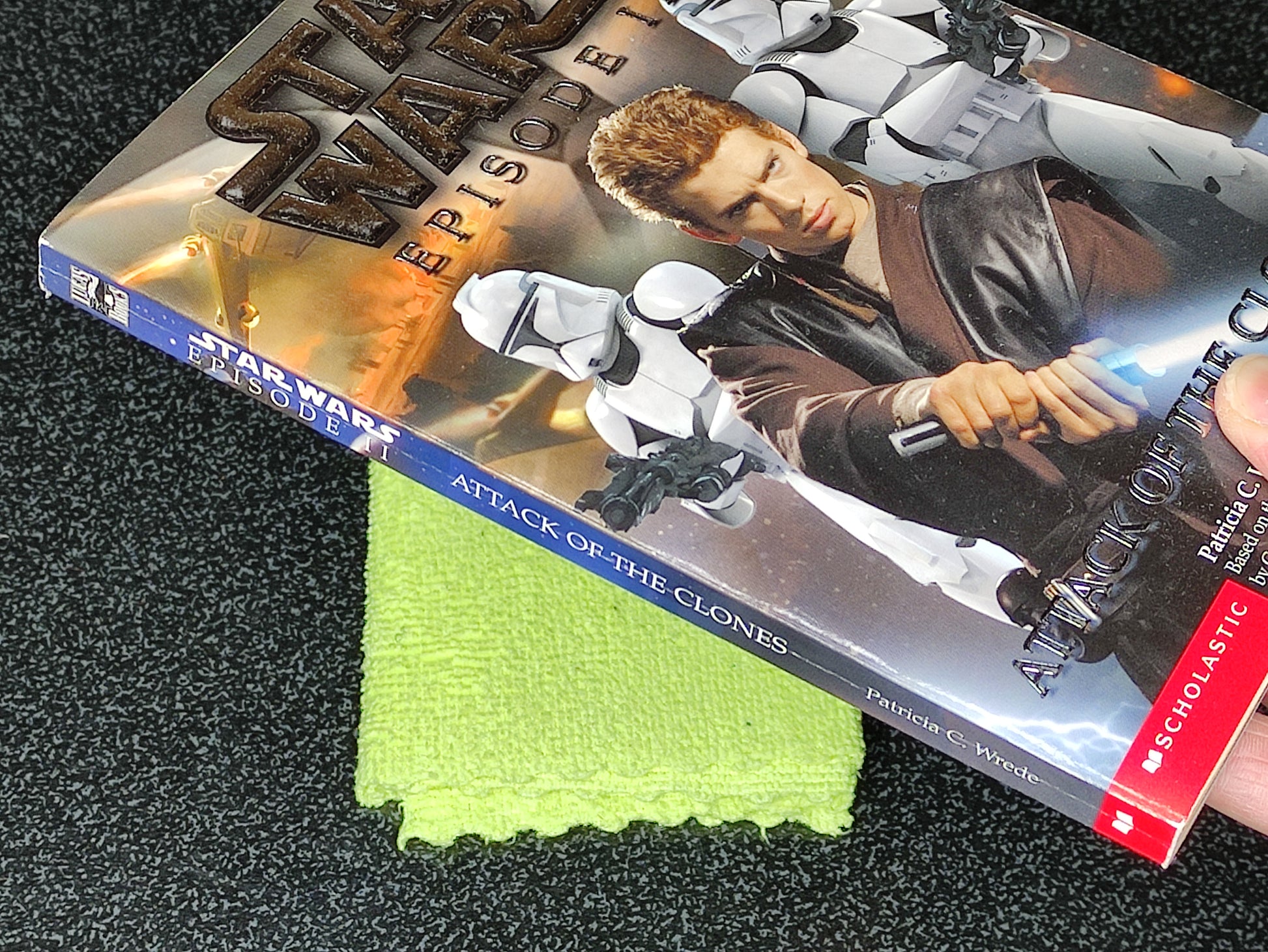 Star Wars book titled 'Attack of the Clones' with a green cloth underneath