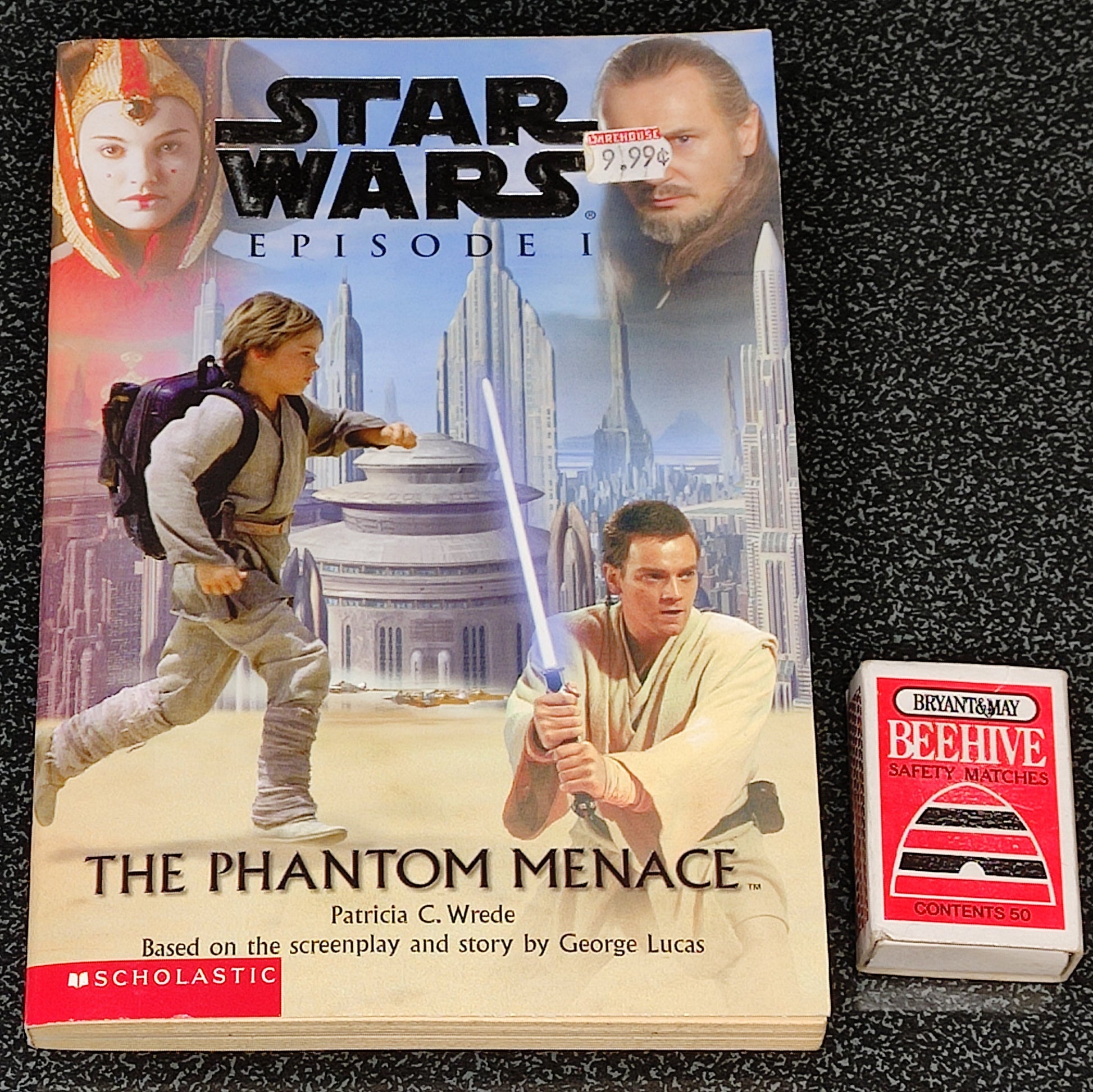 Book titled 'The Phantom Menace' from Star Wars series on a black textured background