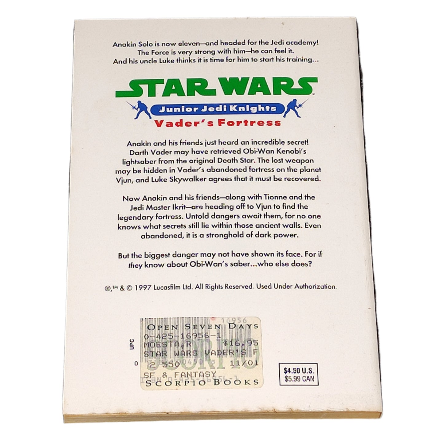 Back of a 'Star Wars' Junior Jedi Knights book titled 'Vader's Fortress' on a textured black surface.