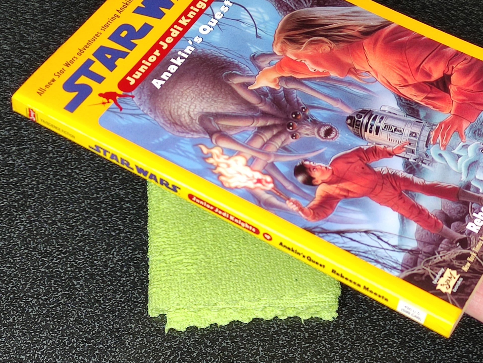 Star Wars Junior Jedi Knight book with a green cloth on a dark surface