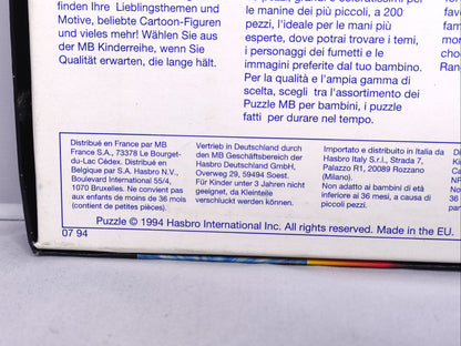 Close-up of a toy box label with text in multiple languages on a gray surface.