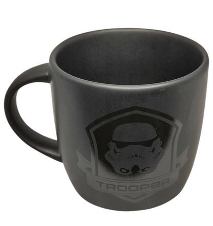 Black mug with 'Trooper' design on a white background