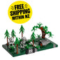 A small toy forest display set on a dark green base, featuring green trees, gray robot figures, a brown tree trunk, and a gray vehicle, with a yellow circular 'FREE SHIPPING WITHIN NZ' badge above it on a white background.